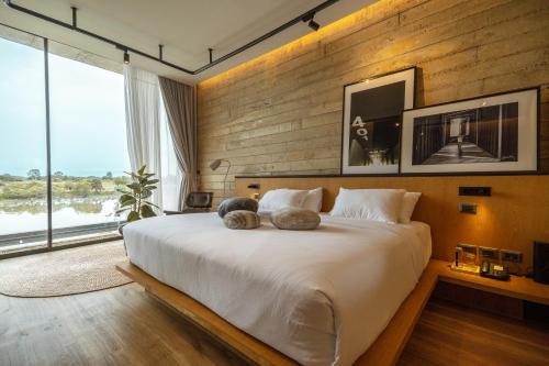 a bedroom with a large bed with two stuffed animals on it at Fallingwater Pool Villa by Cross River Kwai in Kanchanaburi City