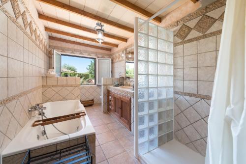 a bathroom with a tub and a sink and a shower at Can Marçal in Marratxí 