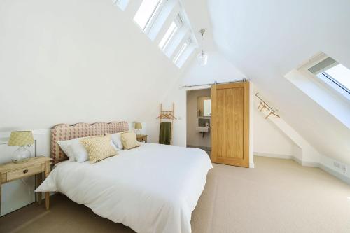 een witte slaapkamer met een bed en een raam bij Hollybank Barn in Dorchester