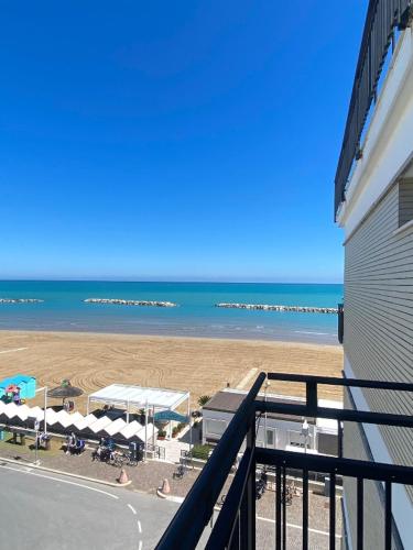 a balcony with a view of a beach with umbrellas at HOTEL FLYING in Pesaro
