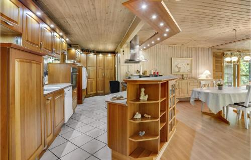 una cocina con armarios de madera y una mesa. en Stunning Home In Herning With Wifi en Kølkær