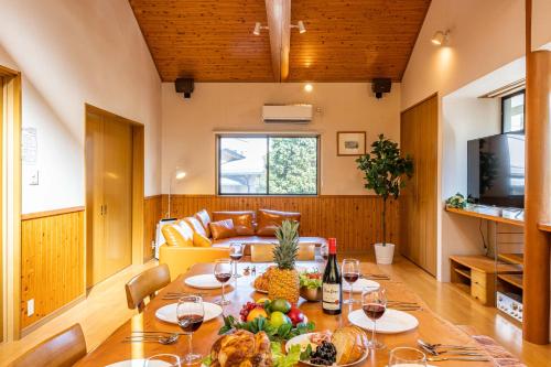 ein Esszimmer mit einem Tisch mit Obst und Weingläsern in der Unterkunft Sayuragi Villa 白浜 in Shirahama