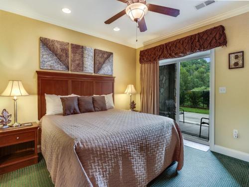 1 dormitorio con 1 cama y puerta corredera de cristal en Downtown Delight, 2 Bedrooms, Pool, Hot Tub, Sleeps 6, en Gatlinburg