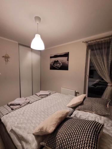 een slaapkamer met een groot bed en een lamp bij Bolszewo Parkowa in Bolszewo