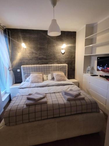 a bedroom with a large bed with a brick wall at Bolszewo Parkowa in Bolszewo