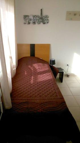 una camera con un grande letto con copriletto rosso di VILLA T3 bord de mer - vue mer à 500 m de la plage- piscine chauffée A CASETTA DI A SPIAGGIA a Cervione