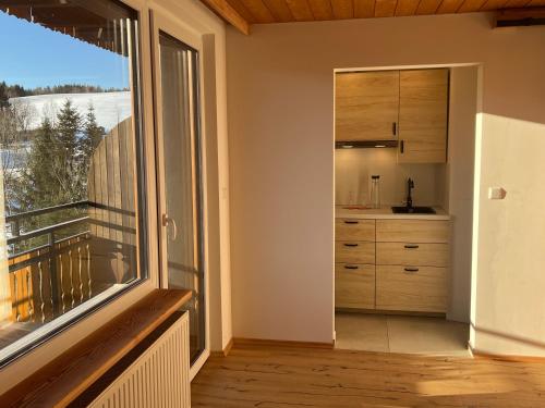 a kitchen with a large window and a balcony at Boutique Hotel and Apartments Pension Sternen in Todtmoos