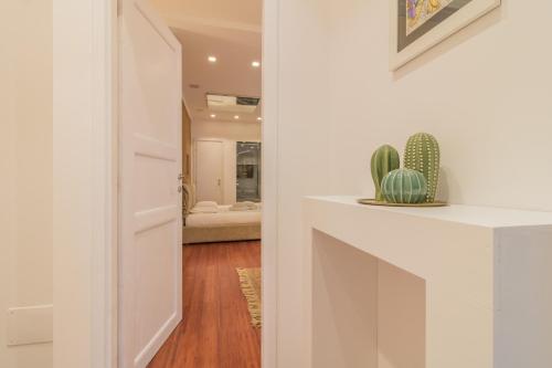 un pasillo con una puerta blanca y un cactus en IL VICOLO suite, en Viterbo
