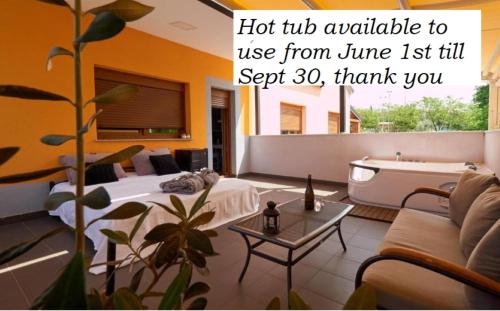 a living room with a bed and a tub and a plant at Wellness Villa Istriana in Umag