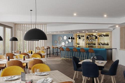 un restaurante con mesas y sillas y un bar en HotelHafenWedel en Wedel