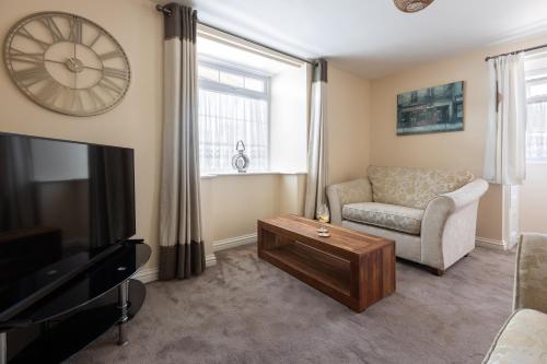 a living room with a couch and a tv at Mabel Cottage in Torquay