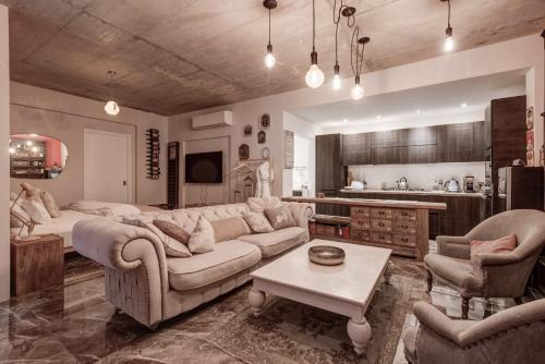 - un grand salon avec un canapé et une table dans l'établissement Talbot and Bons Deluxe Studio Flat, à Gudja