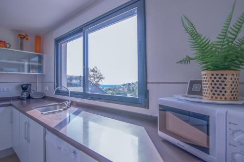 a kitchen with a sink and a large window at Villa moderna con piscina in El Campello