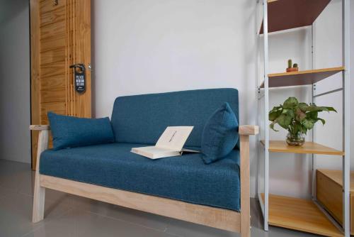 a blue couch with a laptop on top of it at Laewan Guesthouse in Baan Tai