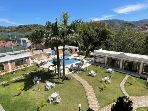 eine Luftansicht auf einen Garten mit einem Pool und einem Haus in der Unterkunft Grand Ville Hotel in São Lourenço