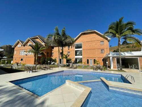 a large swimming pool in front of a building at Grand Ville Hotel in São Lourenço