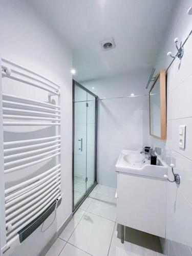 une salle de bain blanche avec un lavabo et une douche dans l'établissement Petit Patio - 2 chambres - Centre ville - Climatisation, à Cassis