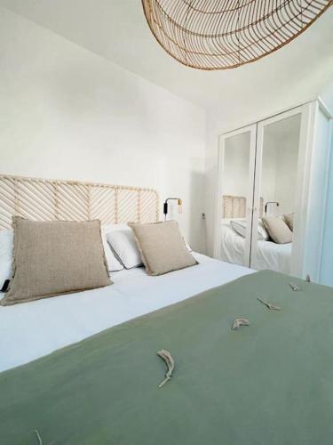 un lit blanc avec deux oreillers dessus dans l'établissement Petit Patio - 2 chambres - Centre ville - Climatisation, à Cassis