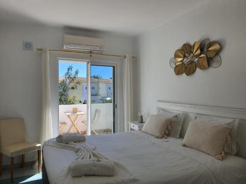 una camera da letto con un grande letto bianco e una finestra di Real Village a Quarteira