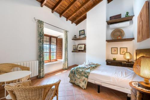 1 dormitorio con 1 cama, mesa y sillas en Cortijo Las Caballerias en Alora