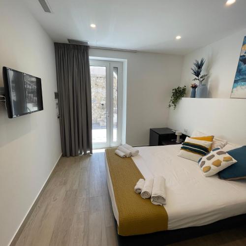 a bedroom with a large bed with towels on it at Namuri Luxury Rooms in Taormina