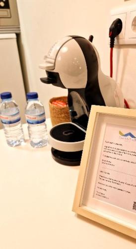 a kitchen counter with a tea kettle and two bottles of water at Casa Vila Praia in Sesimbra