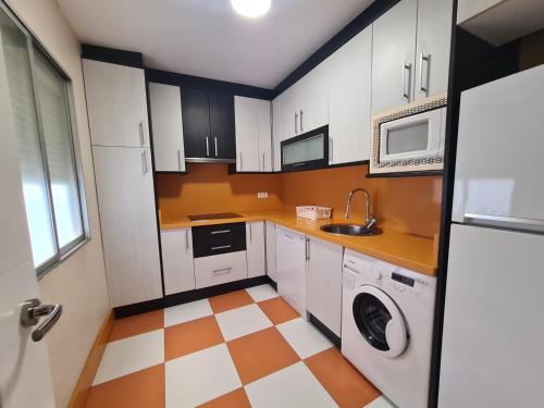 a kitchen with white cabinets and a checkered floor at Apartamento Centro Benidorm Playa in Benidorm