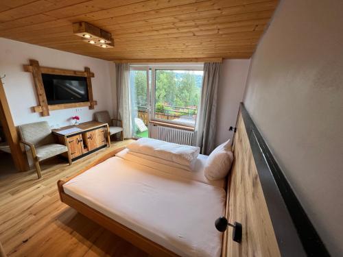 a small bedroom with a bed and a window at Boutique Hotel and Apartments Pension Sternen in Todtmoos