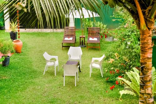 um grupo de cadeiras e mesas num jardim em Villa Paradise Ocean em Bentota