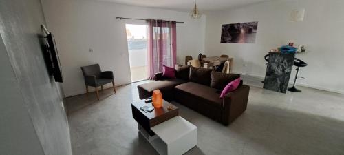 ein Wohnzimmer mit einem Sofa und einem Tisch in der Unterkunft Apartamentos Santiago - Tarrafal in Tarrafal