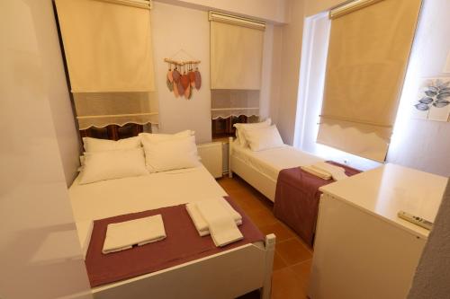um pequeno quarto com duas camas e uma mesa em Cunda Pera Otel em Ayvalik