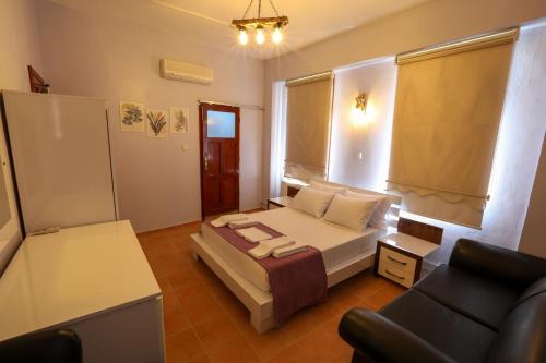 a small bedroom with a bed and a couch at Cunda Pera Otel in Ayvalık