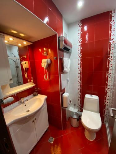 a bathroom with red walls and a sink and a toilet at Mia's Apartment, Stylish One Bedroom Suite in Sofia