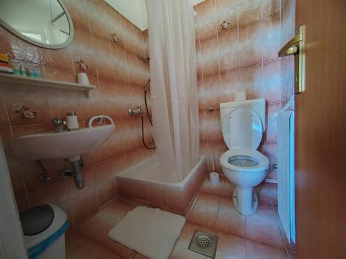 a small bathroom with a toilet and a sink at Cosy room Arba with private bathroom and sea view in Kampor