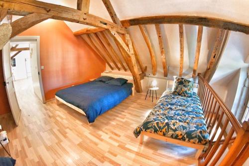 Schlafzimmer mit blauem Bett und Holzboden in der Unterkunft Maison chaleureuse au cœur du perche sarthois in Bessé-sur-Braye