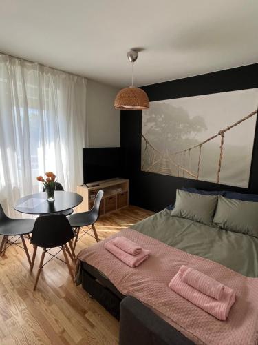 a bedroom with a bed and a table with pink towels at Apartament Sołtysowska- garaż bezpłatny, NEAR Tauron Arena, EXPO in Krakow