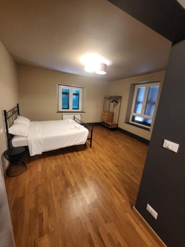 1 dormitorio con 1 cama, suelo de madera y ventanas en 50 SFUMATURE DI SUITE en Génova