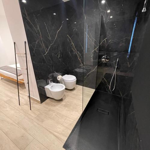 a black bathroom with a sink and a toilet at Namuri Luxury Rooms in Taormina