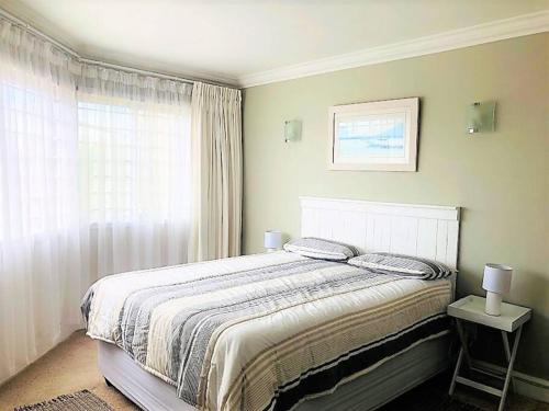 a bedroom with a large bed and a window at Aquarella 1 in Plettenberg Bay
