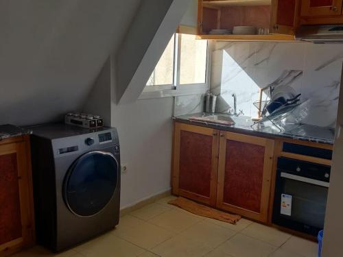 een keuken met een wasmachine en een wastafel bij دوبليكس3 غرف مع طابق علوي خشبي على الطراز التركي in Ifrane