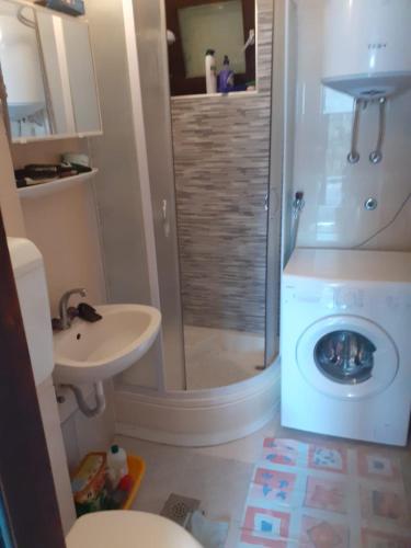 a bathroom with a shower and a washing machine at Josip 1 Gajac in Novalja