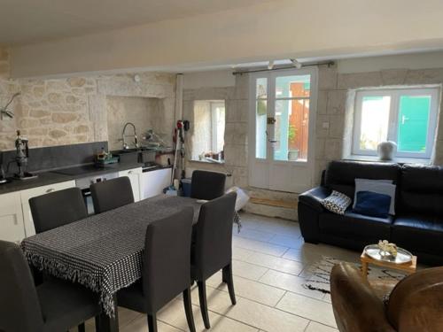 een keuken en een woonkamer met een tafel en een bank bij Maison confortable in Espéraza