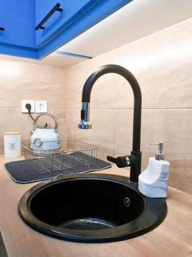 a sink in a kitchen with a black sink at Maison De Prestige in Chalkida