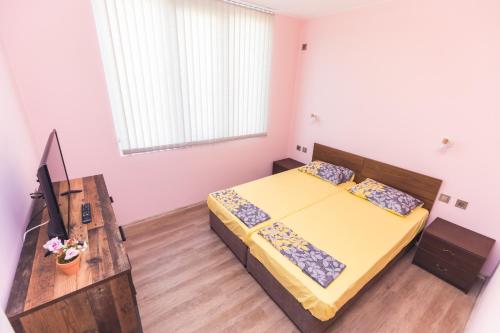 een slaapkamer met een bed, een bureau en een televisie bij Апартамент за гости Боряна in Boergas