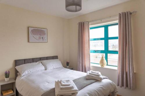 a bedroom with a bed and a window at City Centre Riverview Apartment in Derry Londonderry