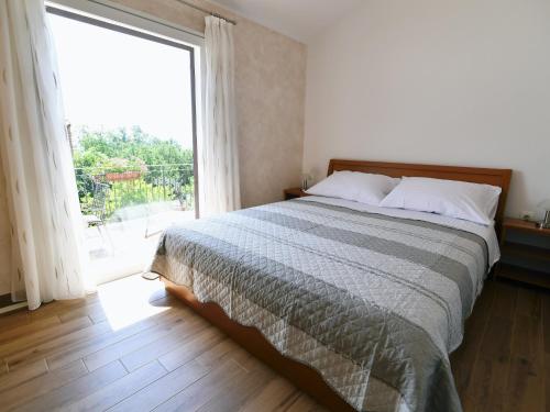 a bedroom with a large bed and a large window at Holiday Home, Apartment and Rooms Milica in Mošćenička Draga