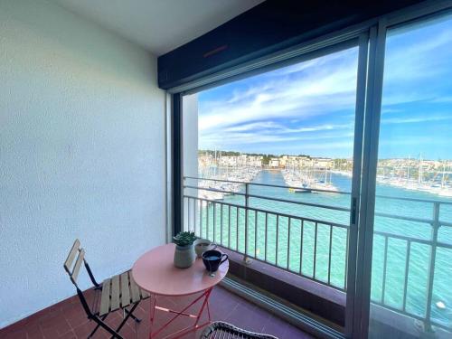 d'un balcon avec une table et une vue sur l'eau. dans l'établissement Appartement vue sur le port, à Gruissan