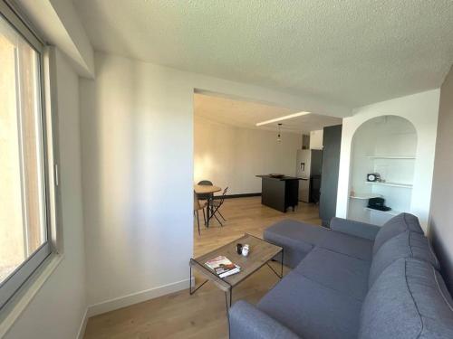 un salon avec un canapé bleu et une table dans l'établissement Appartement vue sur le port, à Gruissan