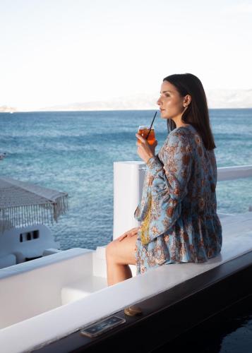 a woman sitting on a boat with a drink at Captain Zeppos in Pollonia