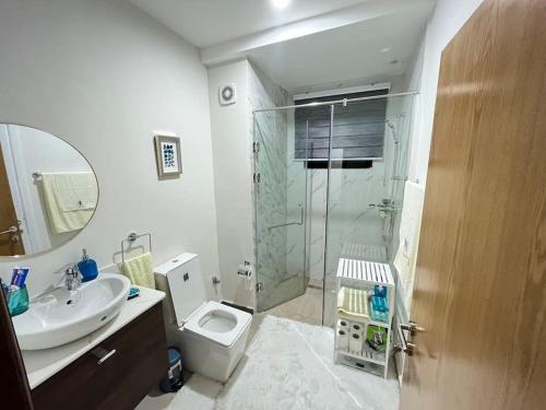 y baño con ducha, aseo y lavamanos. en The Green Escape - Cantonments, en Accra